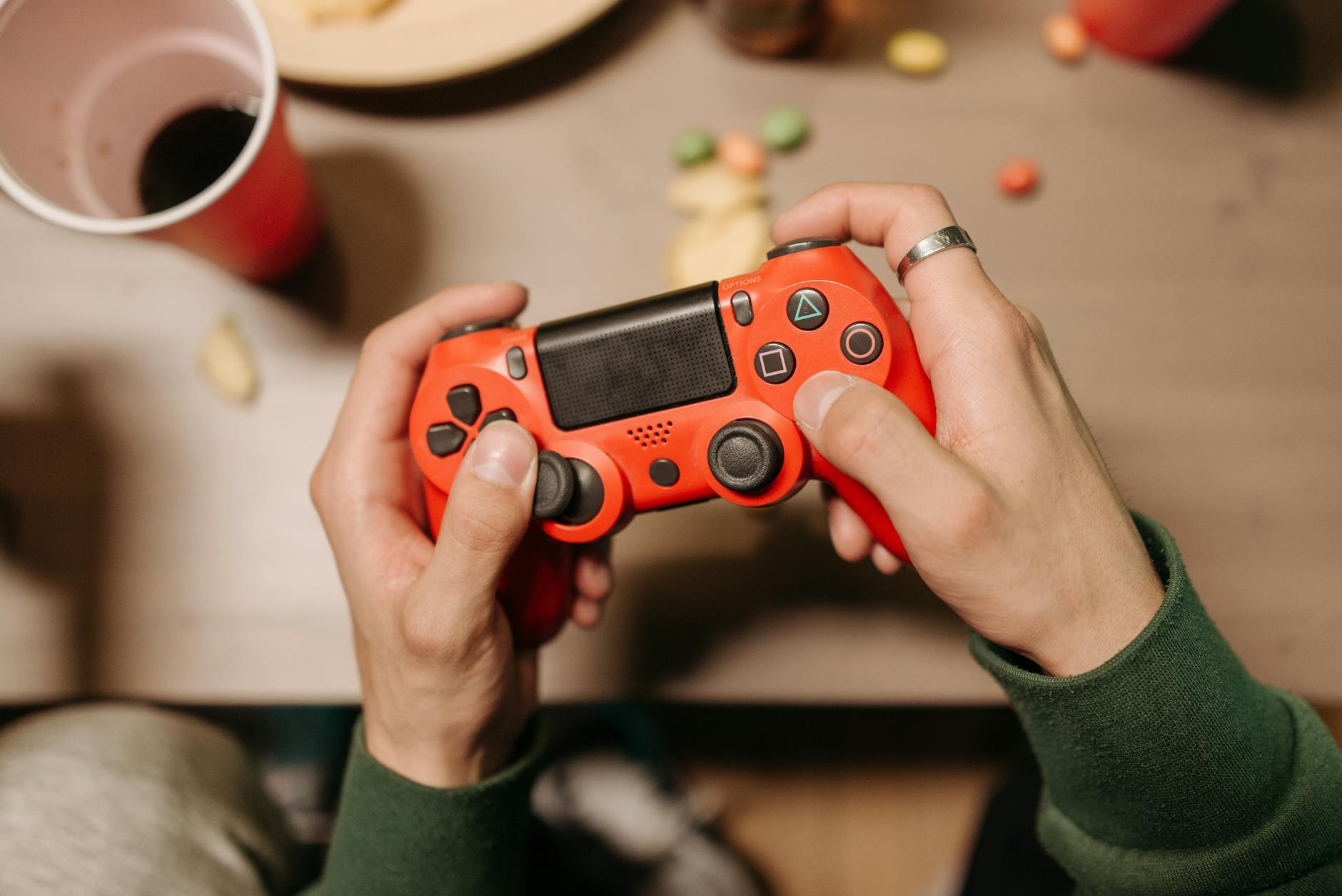 Osoba grająca w MMO na czerwonym padzie przy biurku