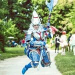 Cosplayer łowca potworów skaczący w dynamicznej pozie na zewnątrz