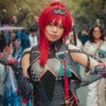 Cosplayer wojownika MMORPG pozuje na zewnątrz podczas wydarzenia
