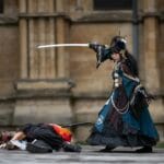 Dwóch cosplayerów walczących mieczami w plenerze