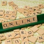 Kafelki Scrabble układające się w słowo online na zielonej podstawce