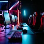 Sala gamingowa z neonami, stanowiskami PC i fotelami na turniej MMO