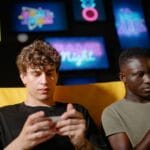 Dwóch znajomych gra w mobilne gry MMO na smartfonach w domu