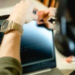 Programista w domowym biurze robi notatki na karteczkach obok kodu Java