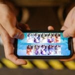 Zbliżenie na dłonie grające w mobilne MMO na smartfonie