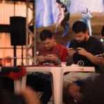 Zawodnicy e-sportowi w skupieniu grają w mobilne MMO na turnieju