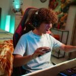 Nastolatek grający w MMO przy nowoczesnym stanowisku gamingowym