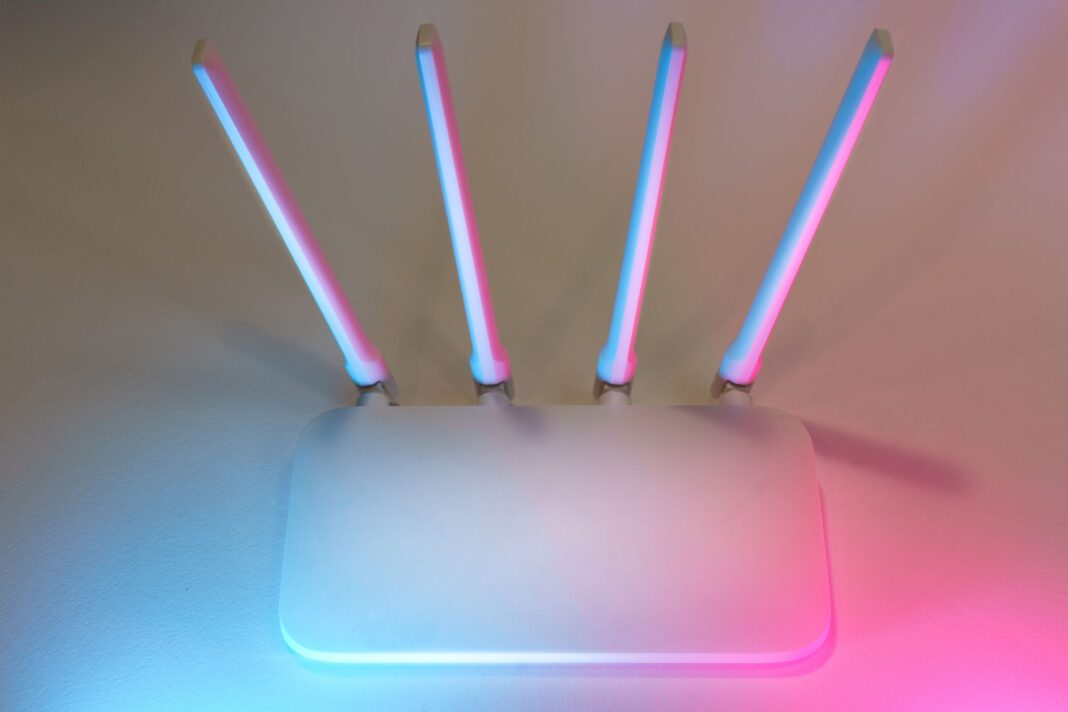 Biały router Wi-Fi z czterema antenami i niebiesko-różowym światłem Biały router Wi-Fi z czterema antenami i niebiesko-różowym światłem