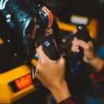 Zbliżenie dłoni trzymających kontrolery do gier arcade